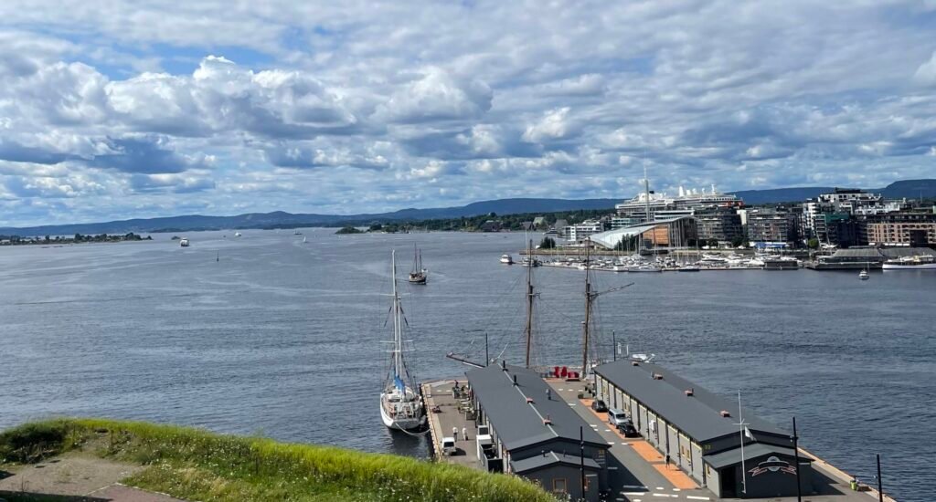 Vista sul porto di Oslo con barche a vela, banchine e il lungomare moderno affacciato sul fiordo