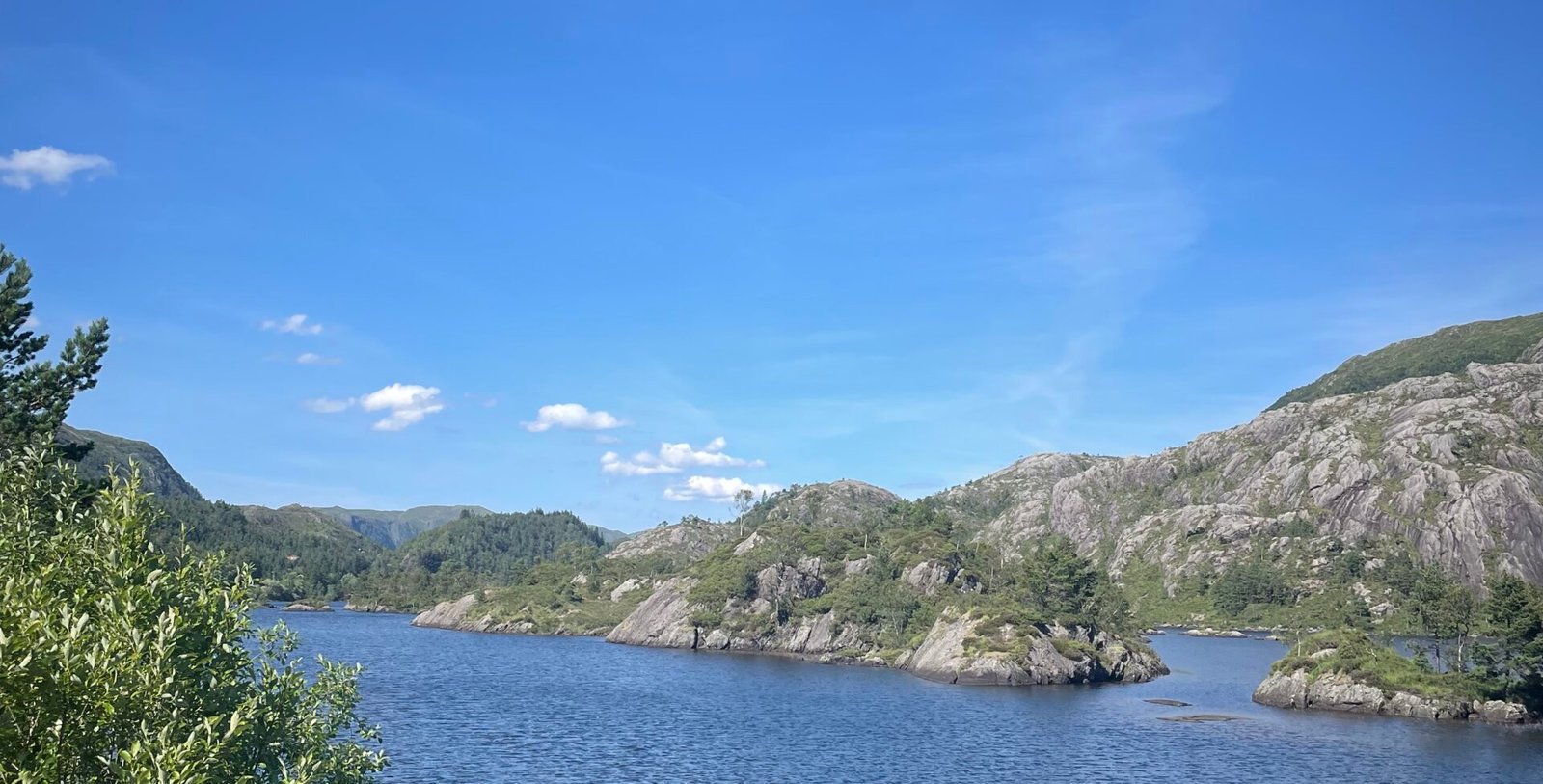 Paesaggio naturale ad Årland, in Vestland, con lago tranquillo circondato da colline rocciose e vegetazione verde