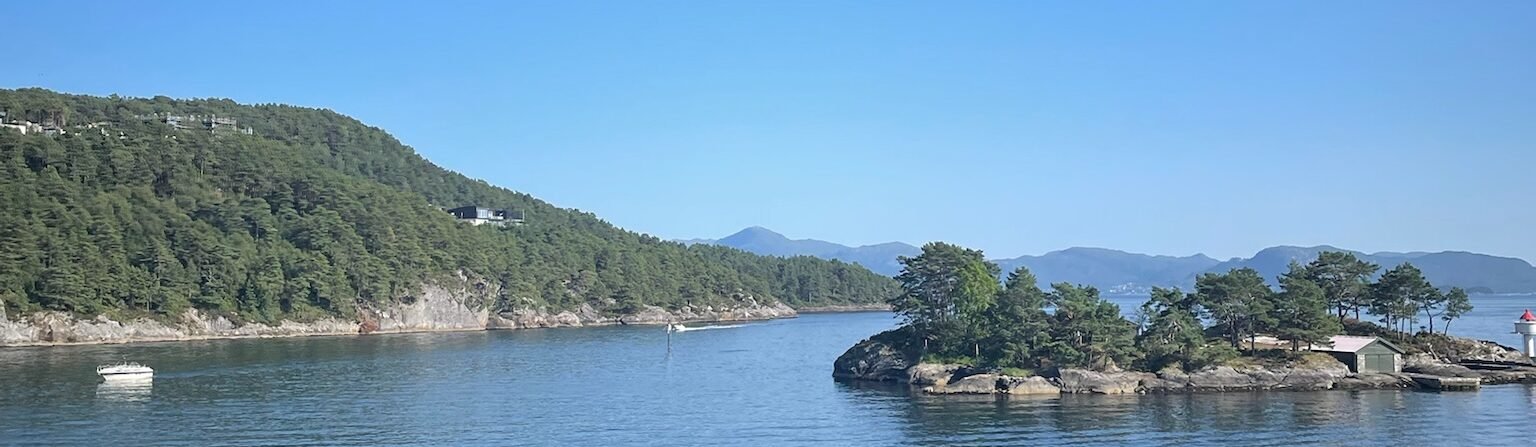 Fiordo norvegese nei pressi di Haljemsøya, a Os (Vestland), con piccole isole boscose e mare calmo