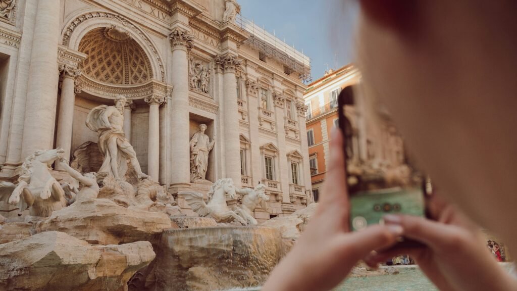 persona che scatta una foto alla fontana di Trevi
